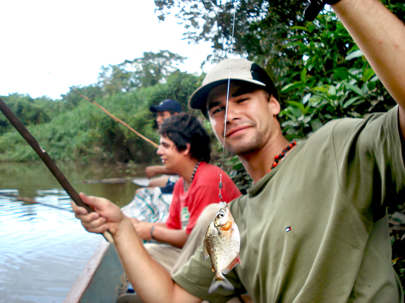 A visitor holding a rainforest fish during a wildlife exploration tour in the Peruvian Amazon.